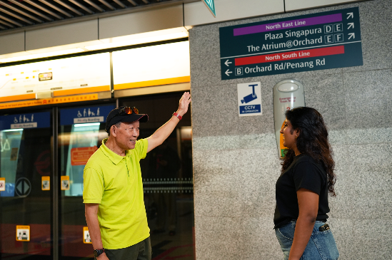 Photo of Michael guiding a commuter with directions at Dhoby Ghaut’s Circle Line Platform.